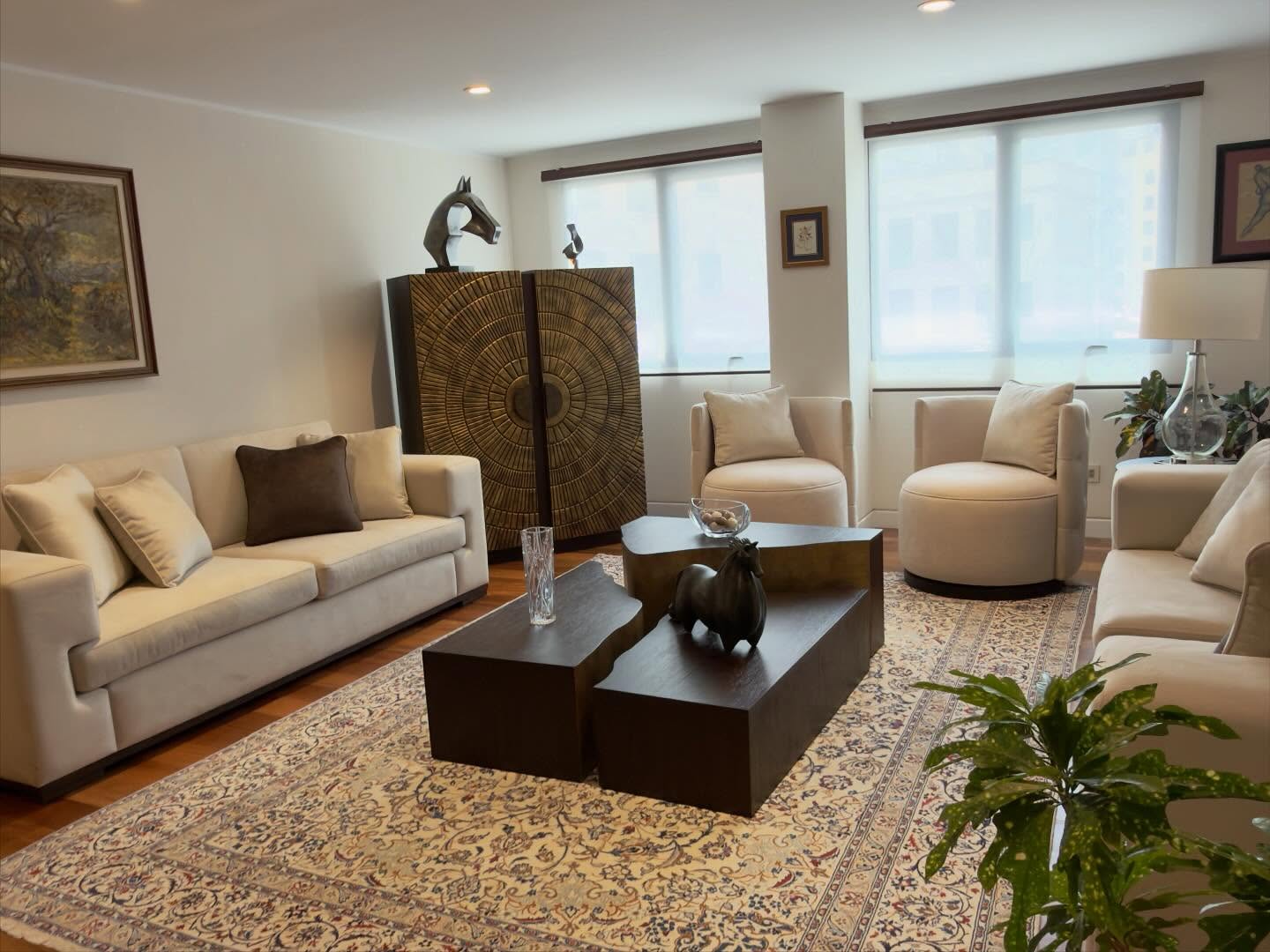 Living de Casa D.S. con alfombra persa, mobiliario y objetos escultóricos